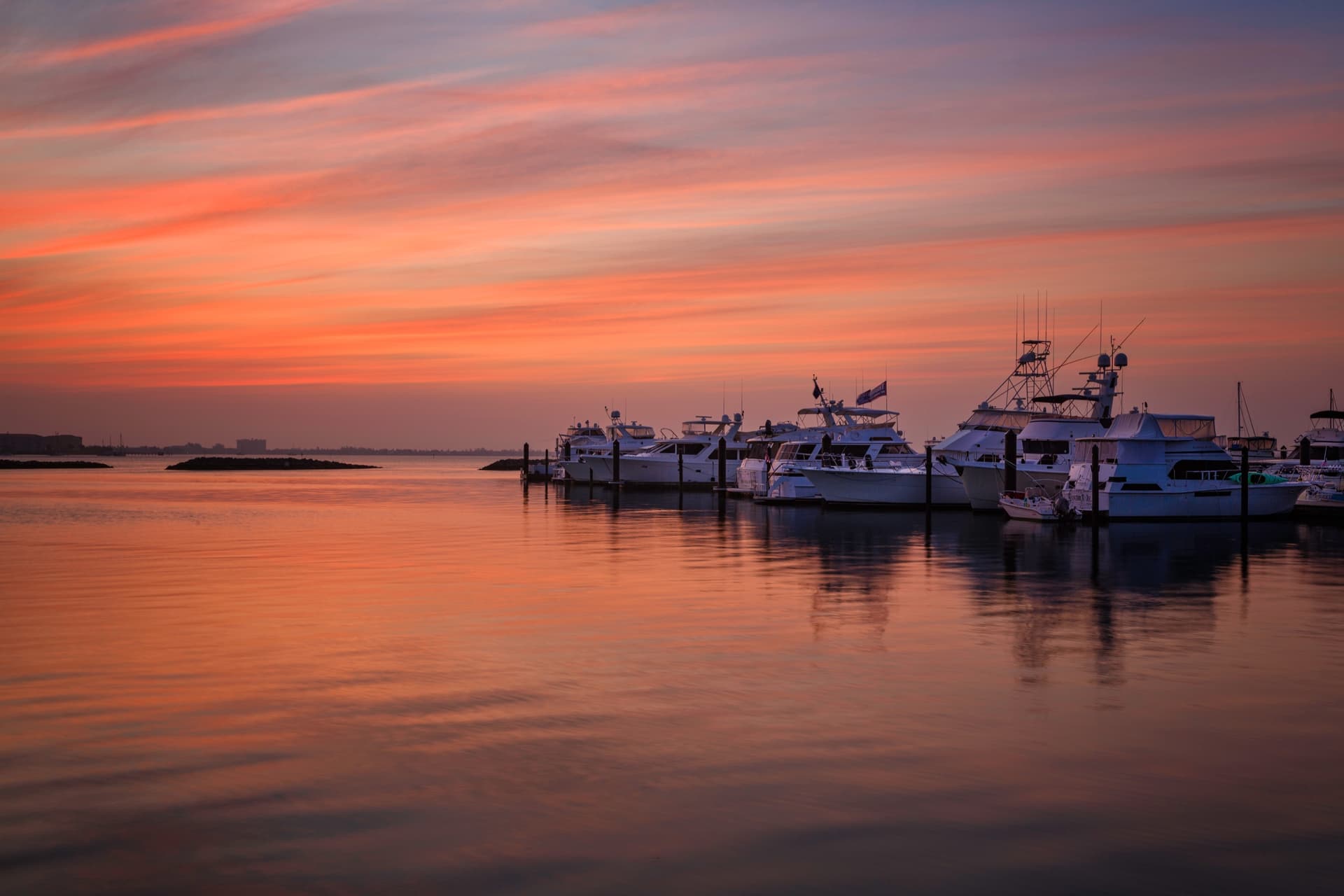 Sunrise over boats gathered in a marina harbor